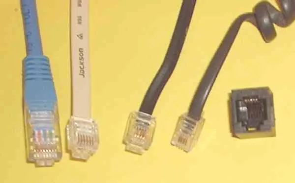 A blue Ethernet RJ45 plug beside smaller telephone plugs and a telephone jack