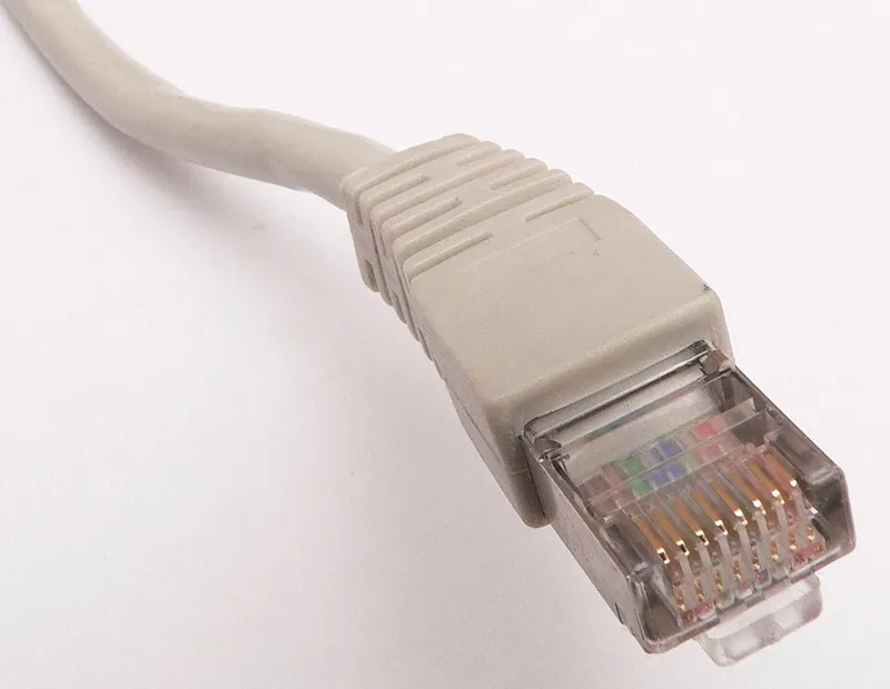 An RJ45 Ethernet plug on a grey patch cable, showing eight gold contacts