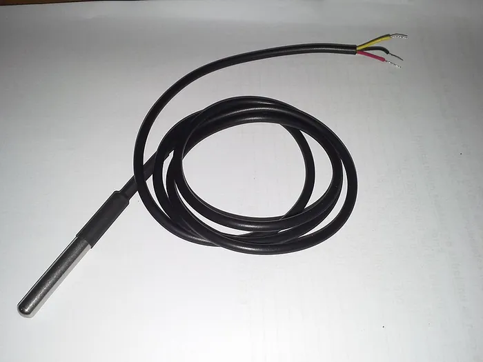 A DS18B20 waterproof temperature probe with its black cable coiled