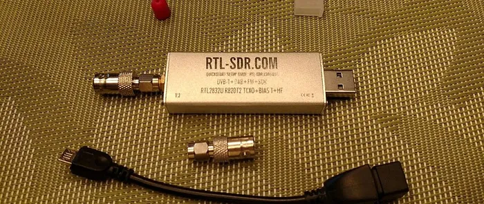 An RTL-SDR dongle with its antenna adapter and USB cable