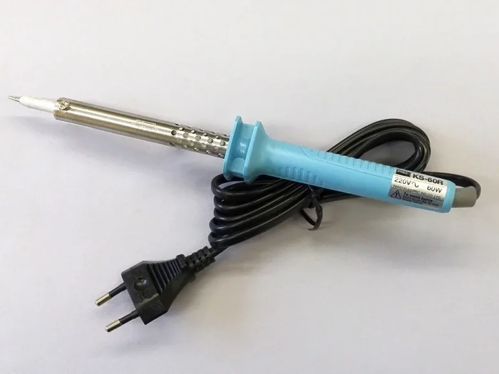 A mains soldering iron with a blue handle and a black cable